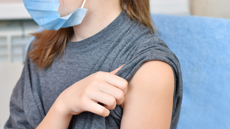 Adolescent rolling up sleeve for vaccine