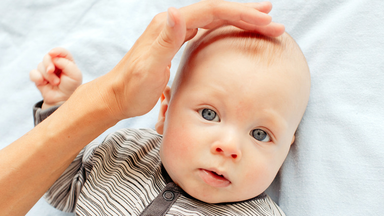 mother stroking the fontanel of her baby