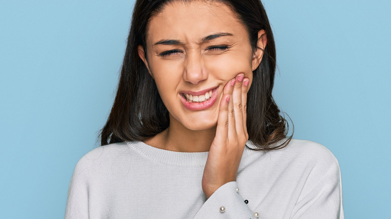 girl holding mouth in pain