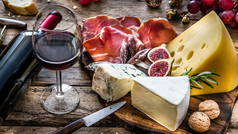 Aged cheese, cured meats, and wine on table