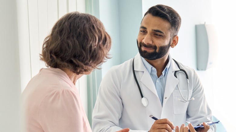 Male doctor having pleasant conversation with female patient