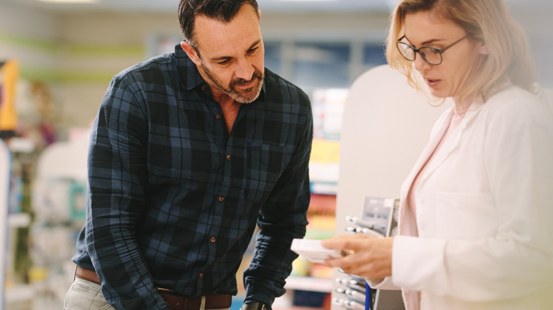 Female pharmacist discussing medications with male patient