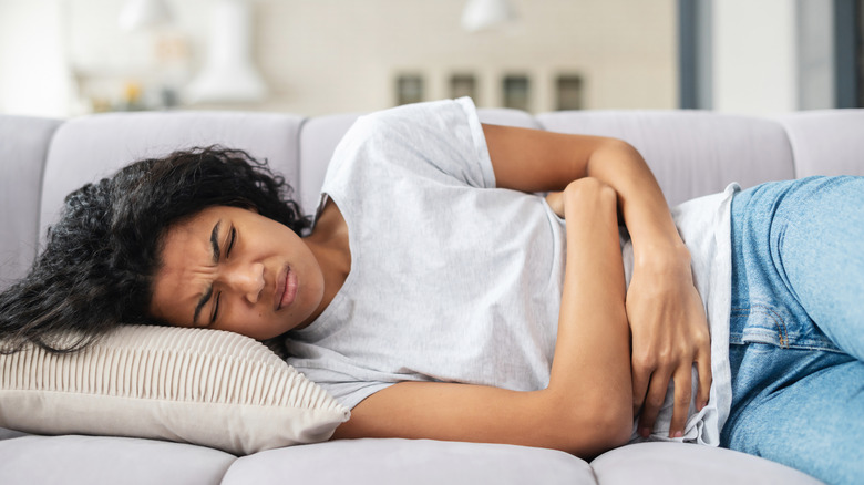 a woman on the couch with period cramps