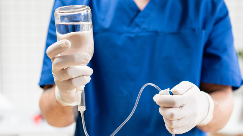 doctor holding IV fluids and infusion pump