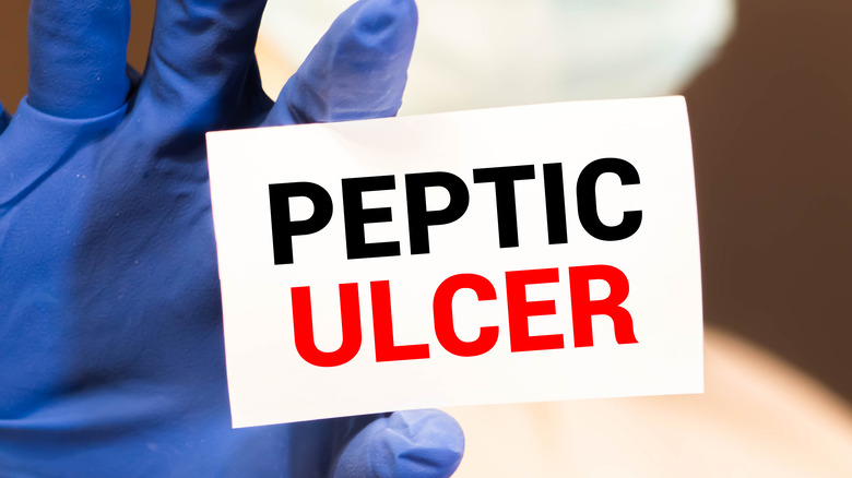 doctor showing card with "Peptic Ulcer" 