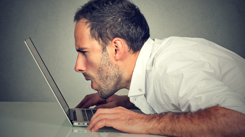 Man leaning close to laptop screen