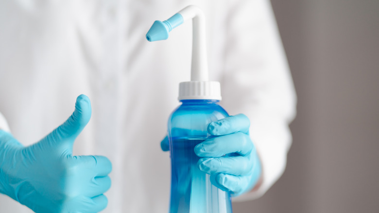 Doctor with nasal wash bottle giving thumbs up