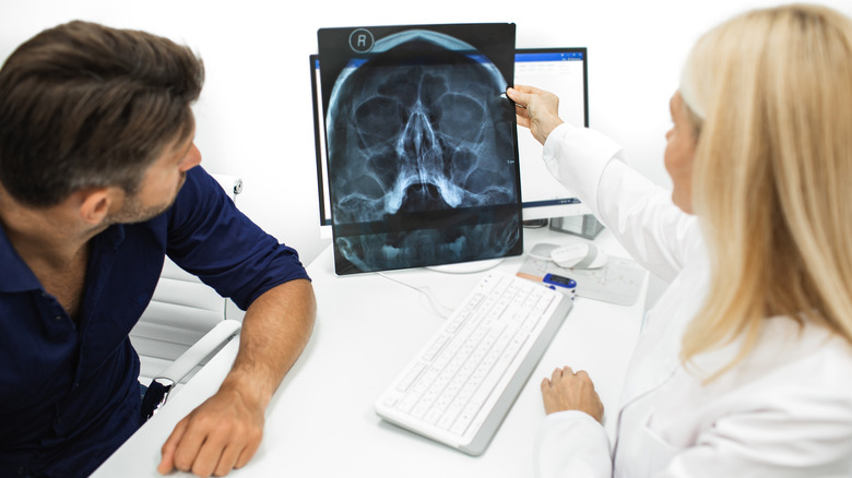 Physician showing a patient an X-ray of head and maxillary sinuses 