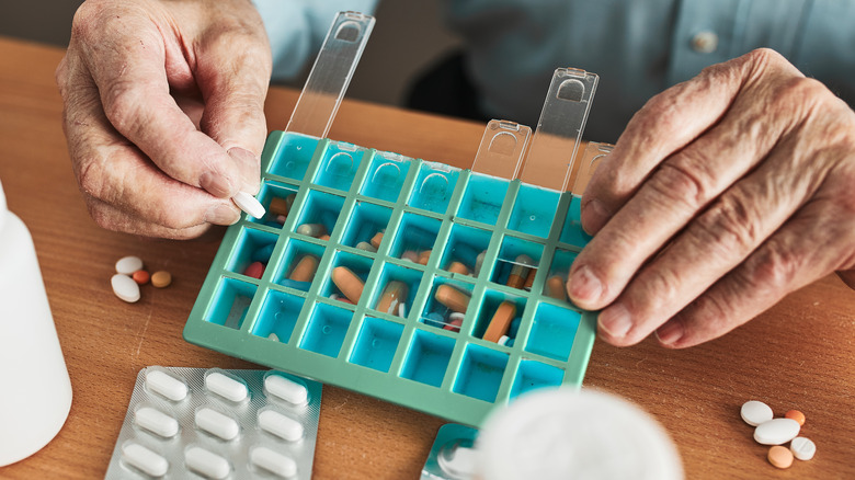 man organizing daily pills