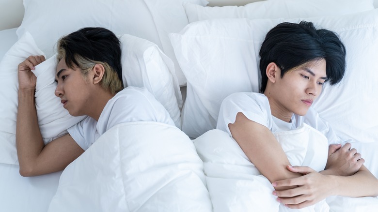 unhappy couple lying in bed