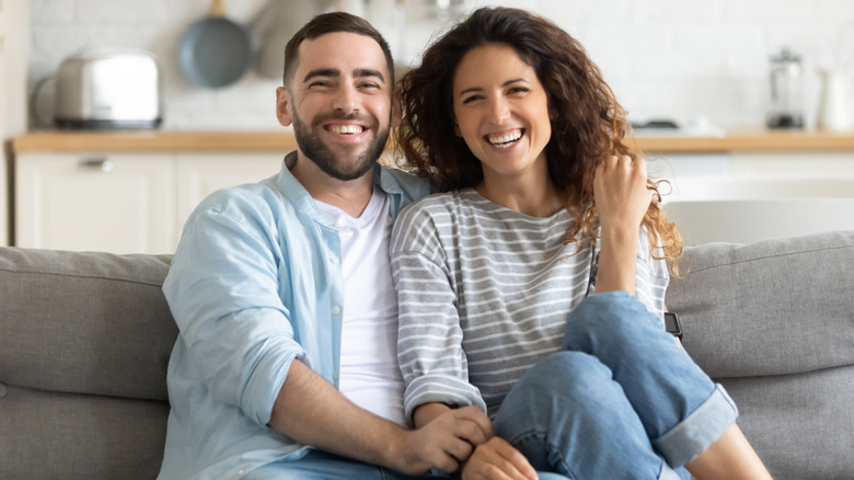 Smiling couple sitting on couch