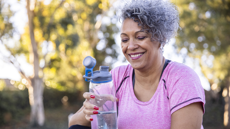 Exercising woman holding water bottle