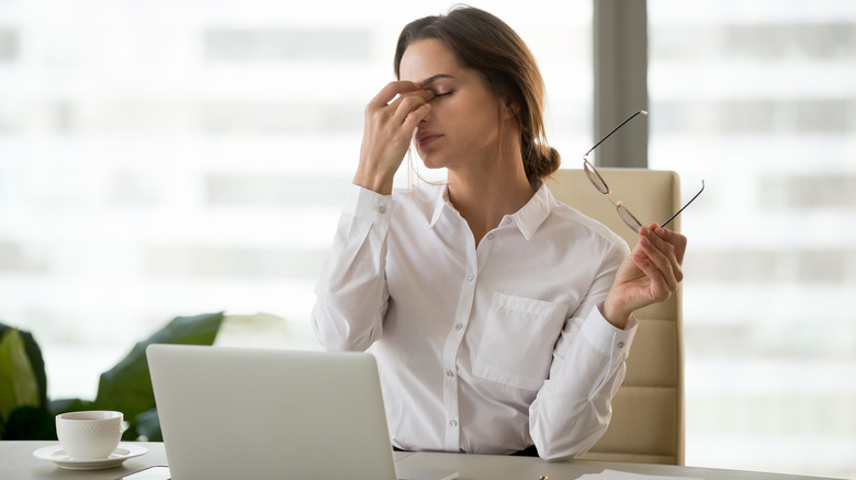 business woman touching eyes in pain