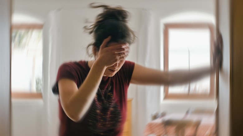 person holding head with room spinning