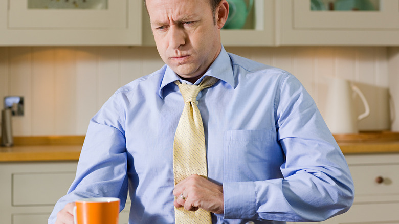 man holding his chest with indigestion