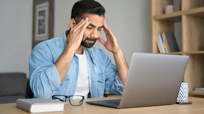 man working at computer with headache