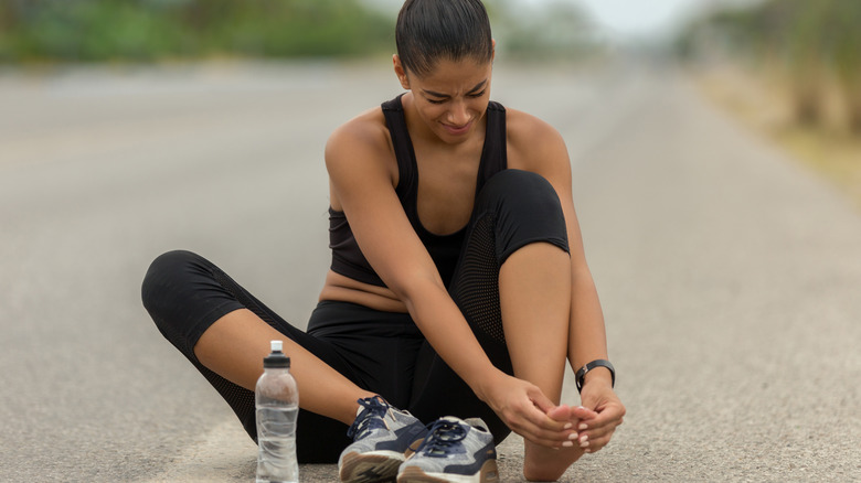 Woman looking at foot on road