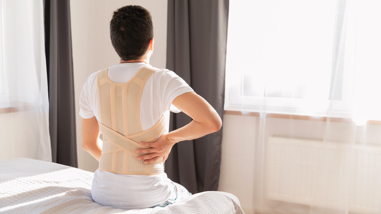 A hospital patient wears a back brace