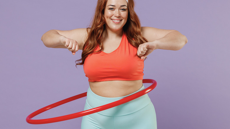 woman hula hooping against purple background