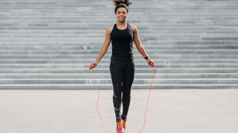 woman wearing all black jumping rope