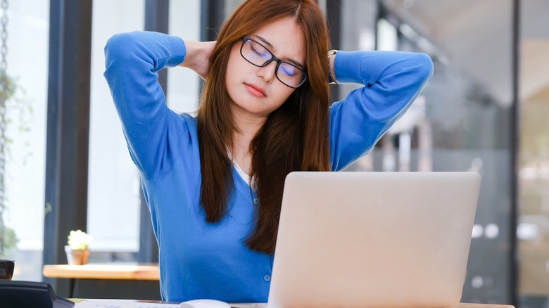 Woman doing neck stretch in chair