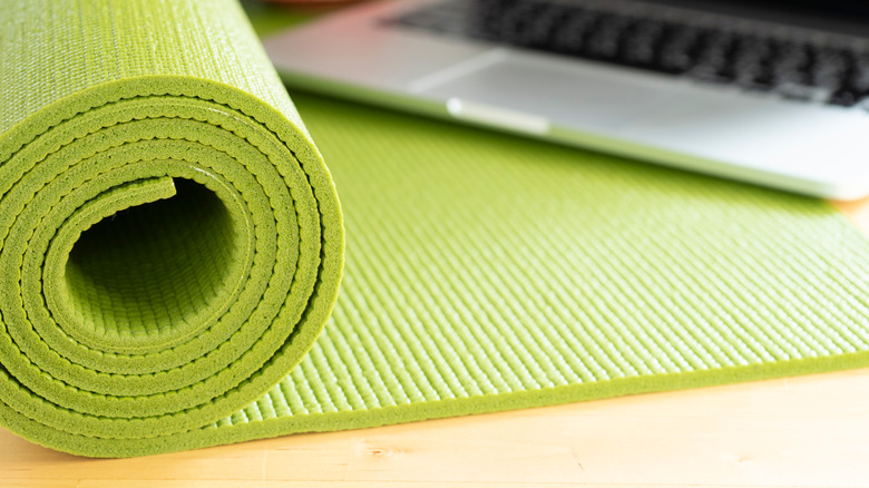 green yoga mat with laptop