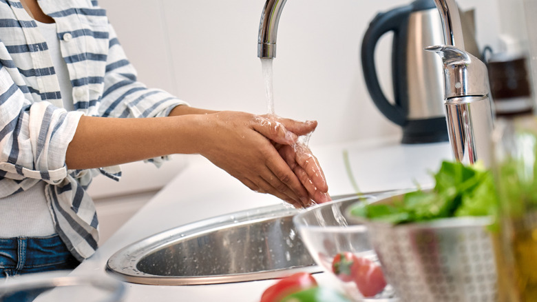 Woman washing hands before preparing food