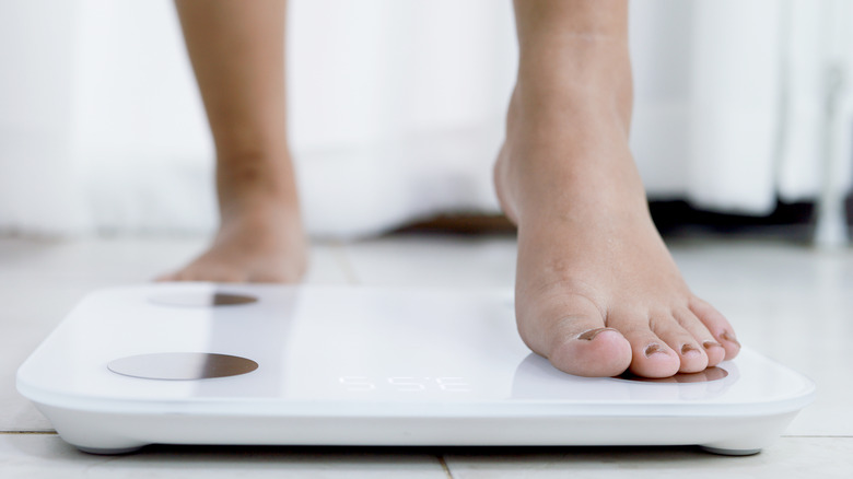 a woman stepping on a scale 