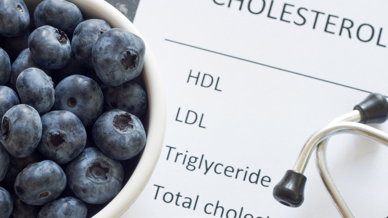 cholesterol test results, stethoscope, and blueberries