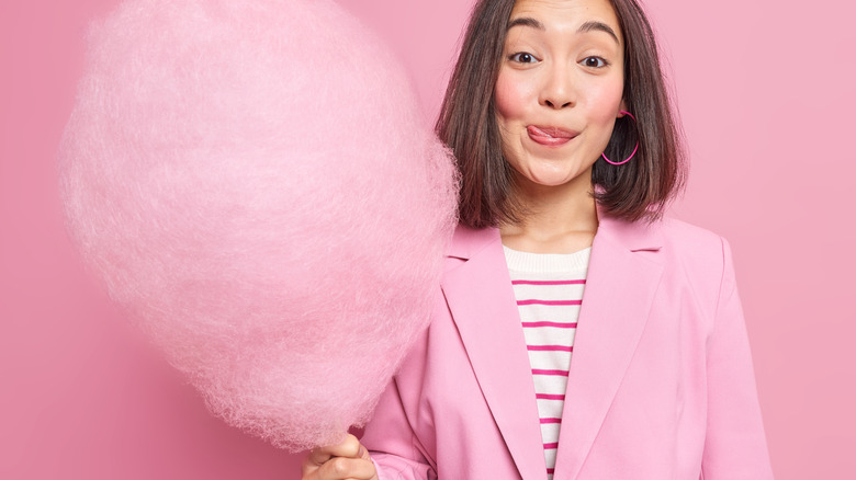 woman holding giant cotton candy stick