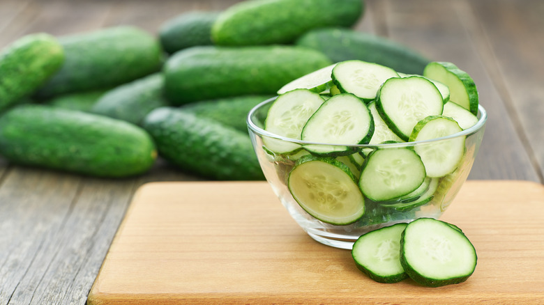 Cucumber slices in glass bowl on wooden table