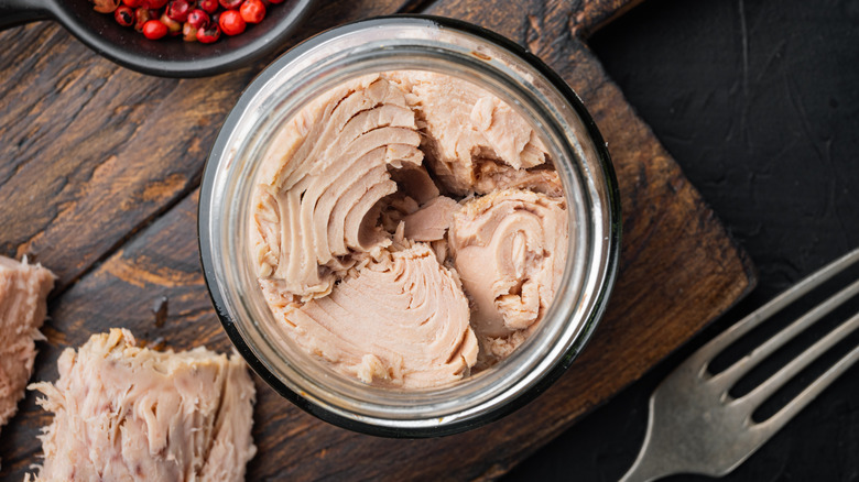 Top view of canned tuna on wooden table