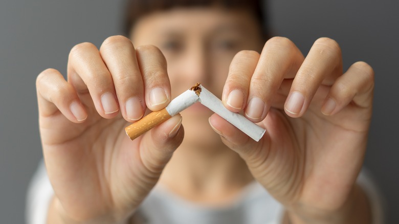 female hands breaking cigarette 