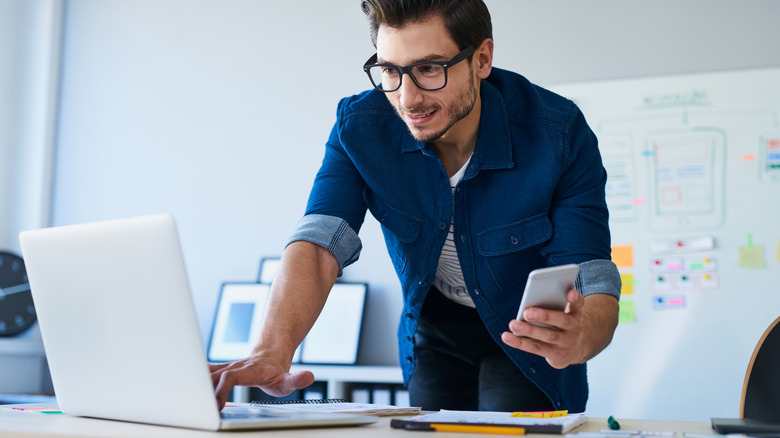 man standing while working and talking on phone