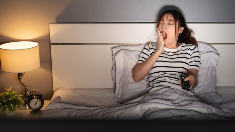 Woman watching TV in bed