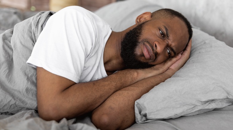 Tired man laying in bed