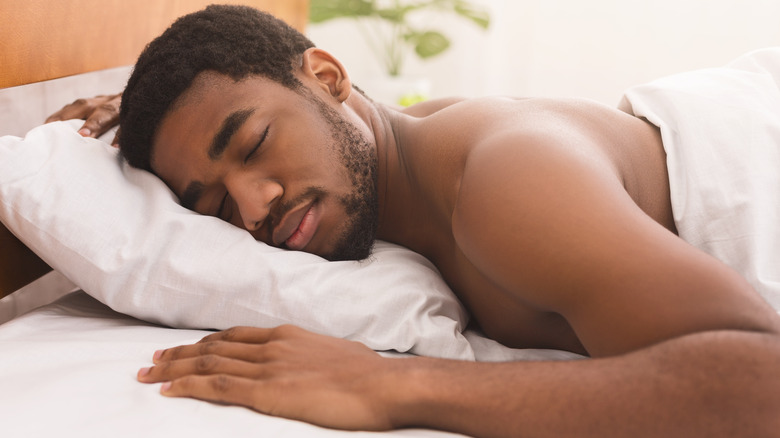 man sleeping naked in bed