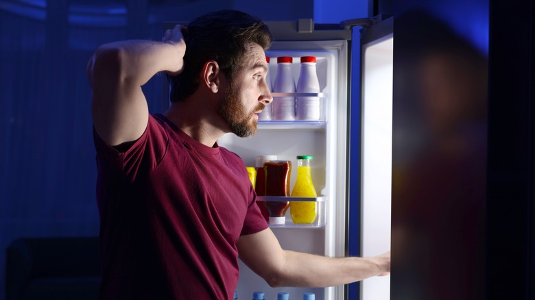 Man looking in fridge for midnight snack