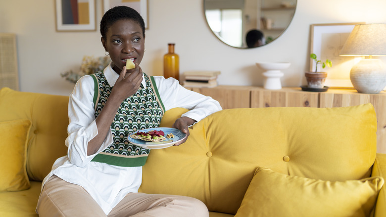 Woman eating healthy snack on the couch