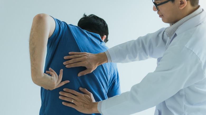 Healthcare provider assessing back pain