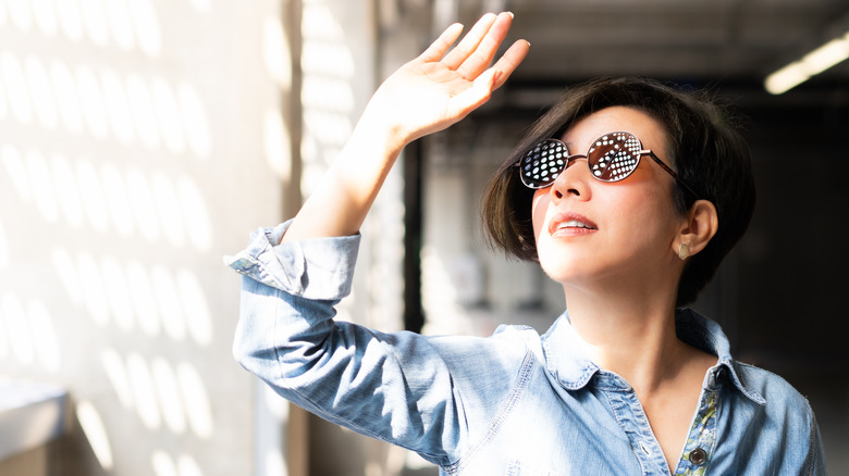 A woman shields her eyes from the sun