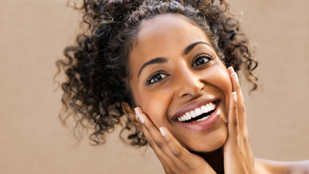 smiling woman holding face