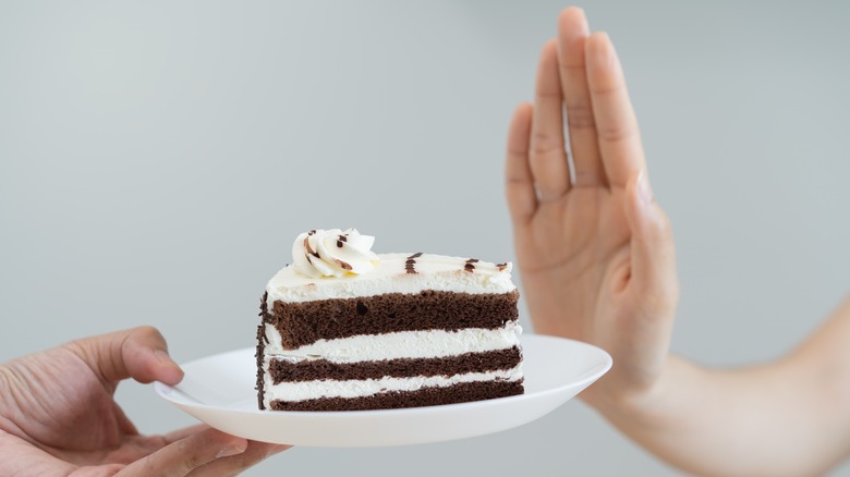 person refuses a slice of cake