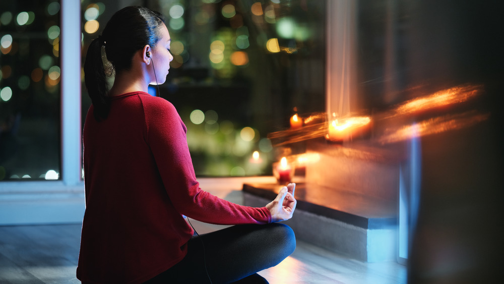 A woman doing yoga in her living room at night