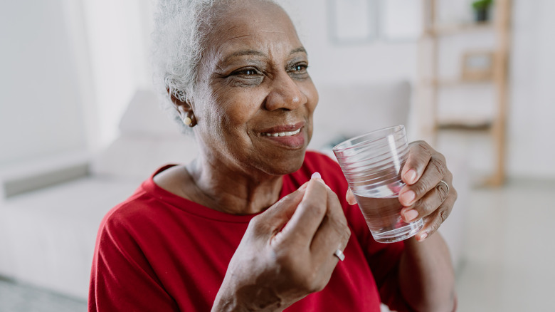 Smiling woman taking medication