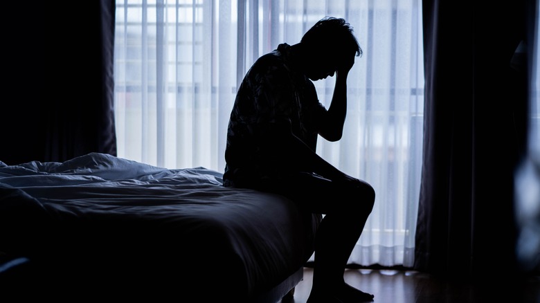 Depressed man sitting on the bed