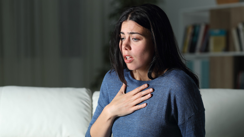 stressed woman covering heart with hand