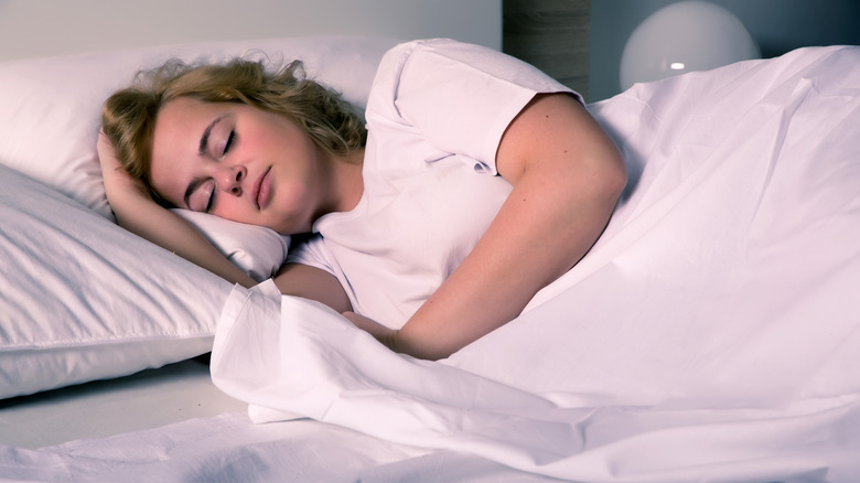 woman on side sleeping in room