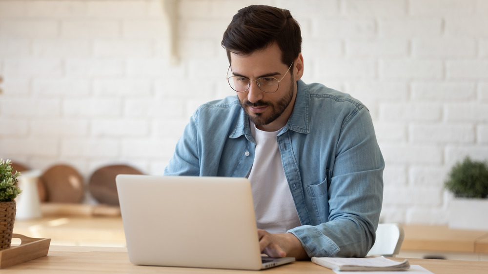 man hunched over computer