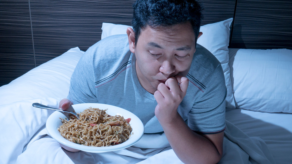 man eating in bed